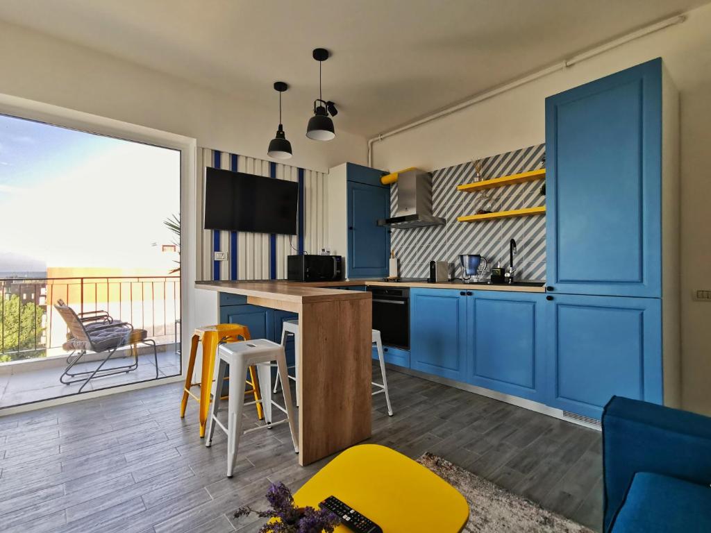 eine Küche mit blauen Schränken und einem Balkon in der Unterkunft Velier Summer Apartment in Mamaia
