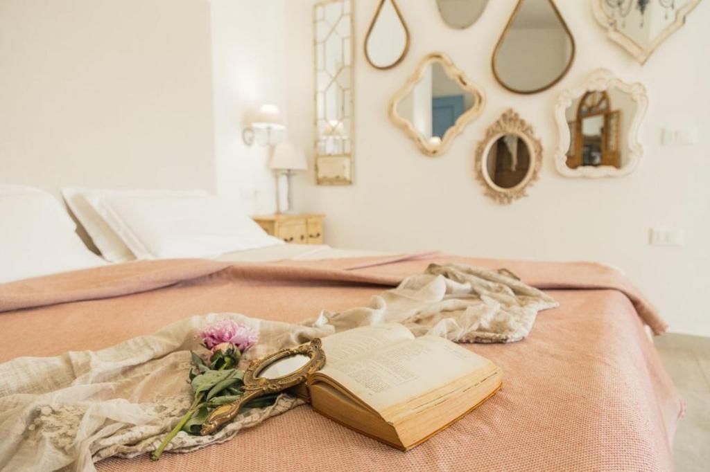 聖瑪麗亞納瓦雷的住宿－安蒂科泰萊奧住宿加早餐旅館，书和一朵花躺在床上