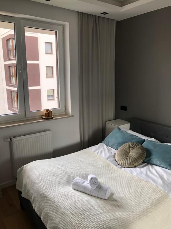 een slaapkamer met een bed met handdoeken en een raam bij Apartament Avior in Iława