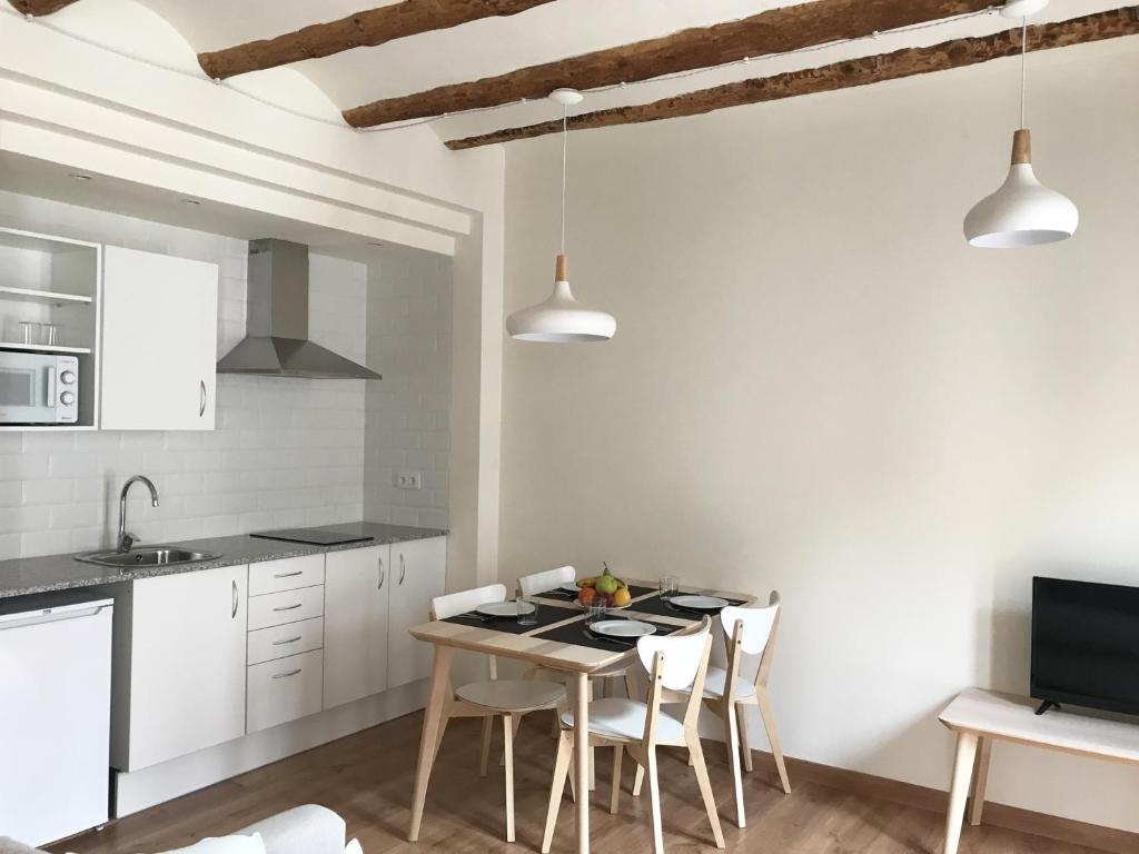 una cucina con tavolo e sedie in una stanza di Apartaments Casa el Metge a Prat de Comte