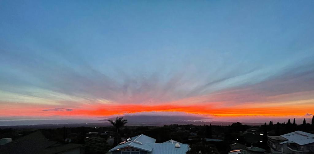 um pôr-do-sol sobre uma cidade com um céu vermelho em Ha'le Kiana em Kula