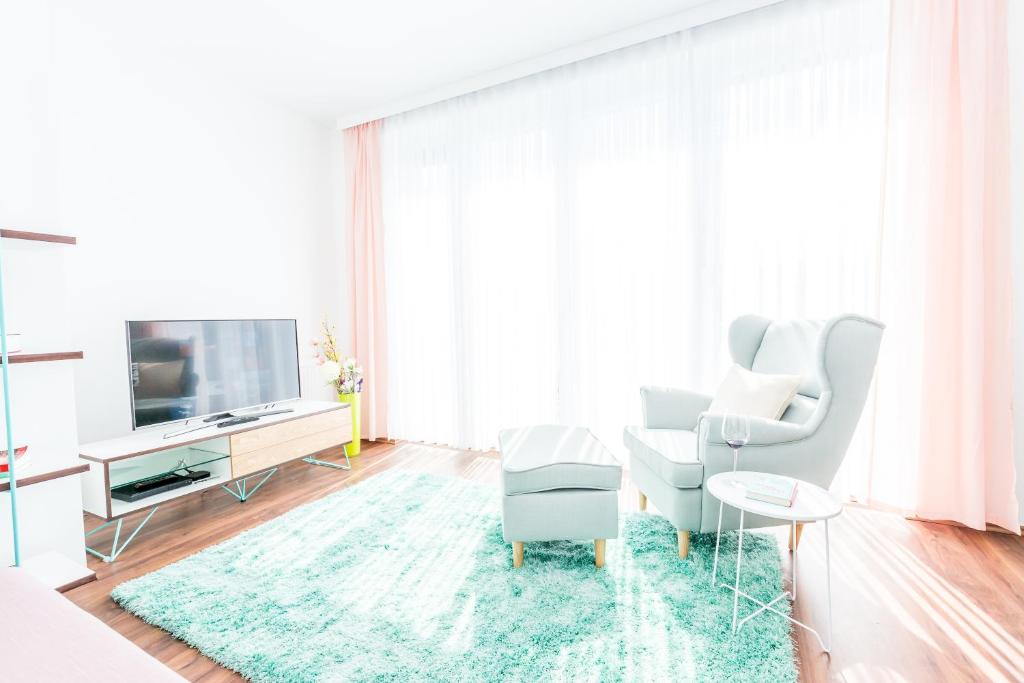 sala de estar con TV, sofá y mesa en Simtown Suite Apartments en Viena