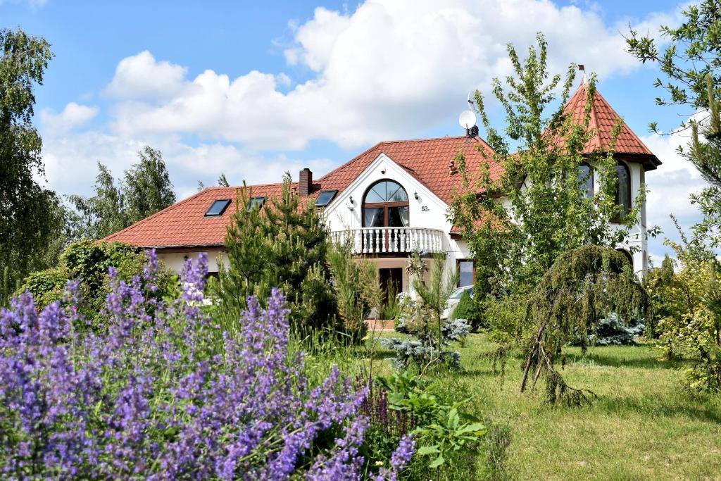 dom z ogrodem i fioletowymi kwiatami w obiekcie "Route 62" Airport Modlin w mieście Goławin