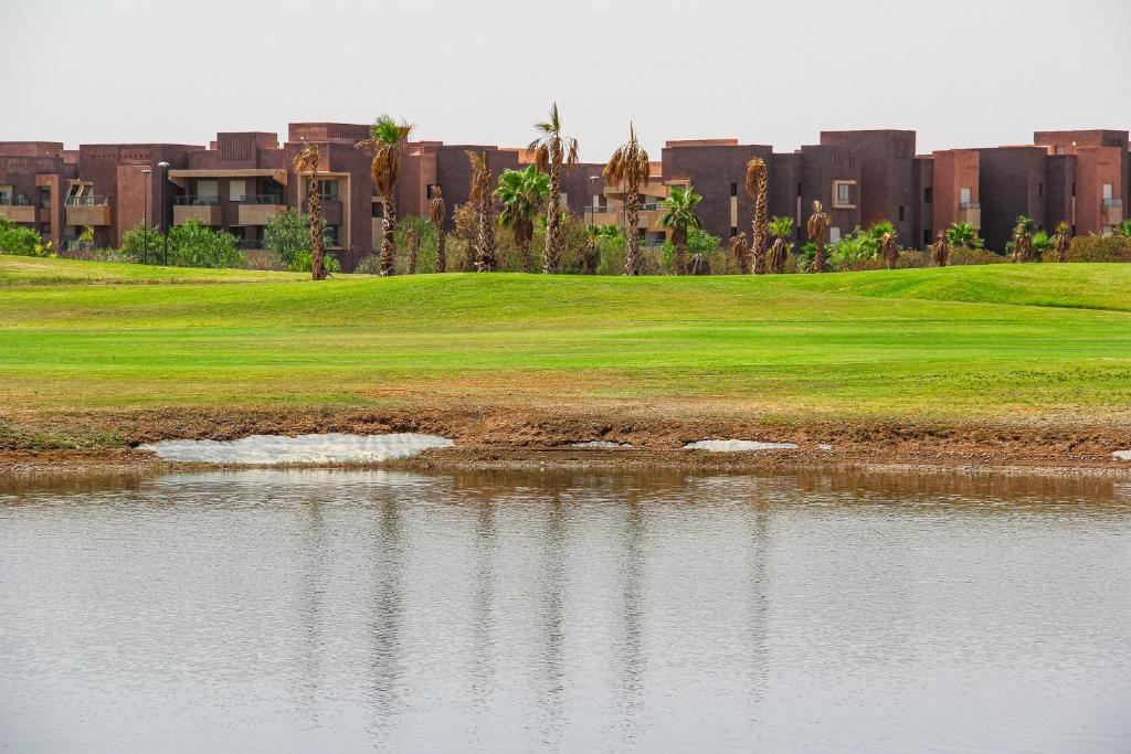 a golf course next to a body of water at Modern Lakeview Apartment With Private Garden in Marrakesh