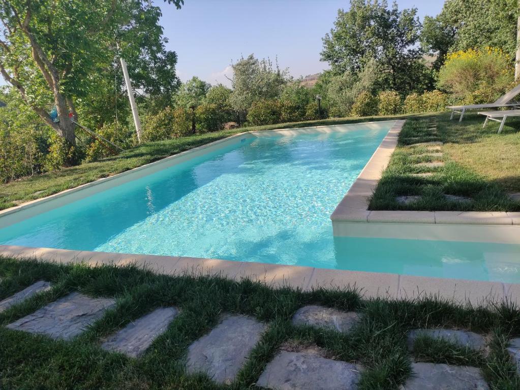 una piscina de agua azul en un patio en Agriturismo La Poderina en Bagno Vignoni