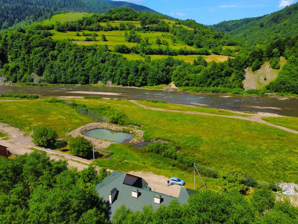 une vue aérienne sur une maison dans un champ avec une rivière dans l'établissement Гостьовий дім "Тая", à Mijgiria