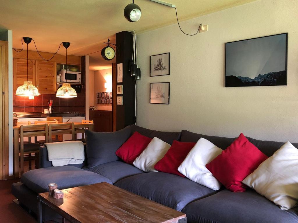 uma sala de estar com um sofá azul com almofadas vermelhas e brancas em CHECK-IN CASAS Cerler 3F em Cerler