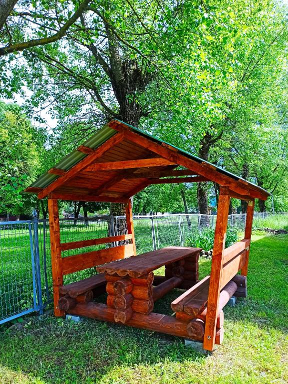 a wooden picnic table and bench in a park at Гостьовий дім &quot;Тая&quot; in Mizhhirya