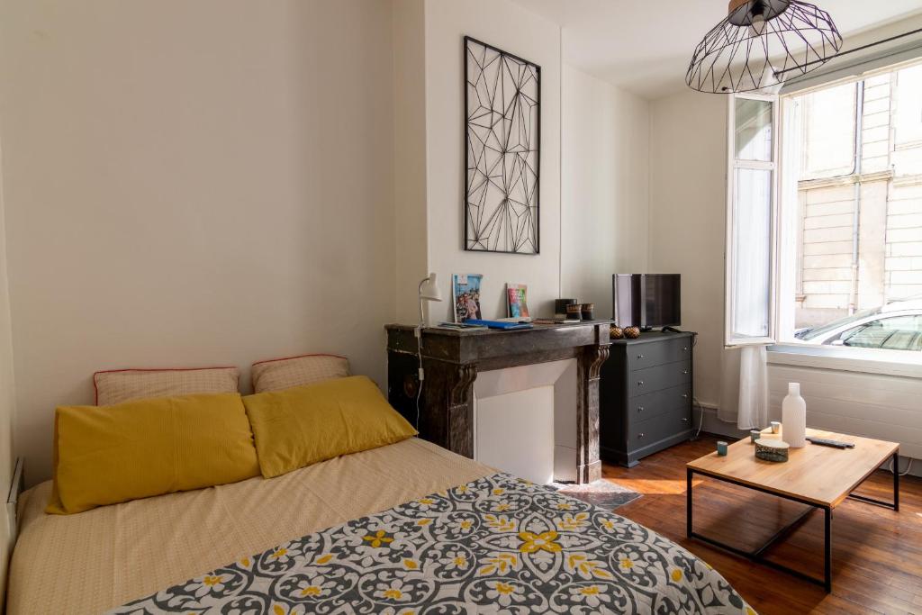 une chambre avec un lit, une table et une fenêtre dans l'établissement Little GAMBETTA, à Saumur