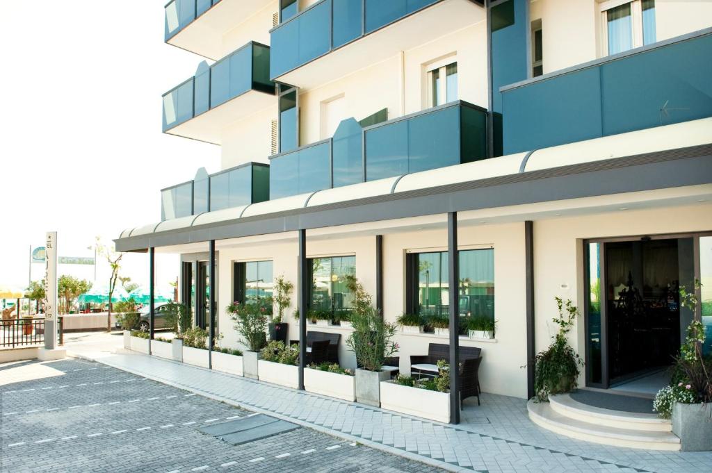 um edifício de apartamentos com grandes janelas e vasos de plantas em Hotel Aurea em Bellaria-Igea Marina