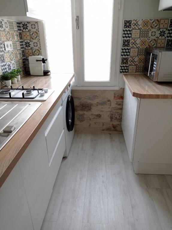 une cuisine avec des armoires blanches et un comptoir dans l'établissement Le coin des Sables, à Les Sables-dʼOlonne