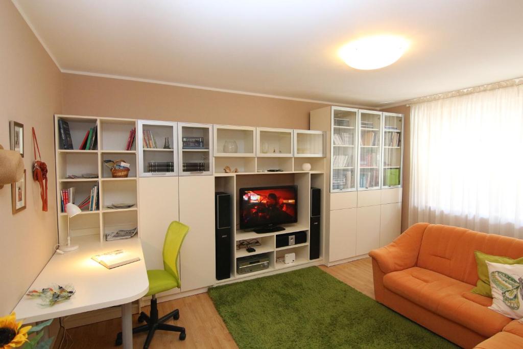 een woonkamer met een tv, een bank en een bureau bij Fast Friend - cozy apartment in the center with private garage in Rijeka