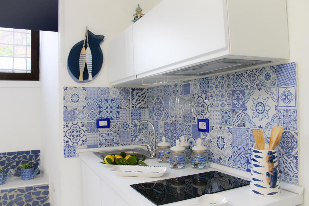 a kitchen with blue and white tiles on the wall at Blue Castle in Salerno