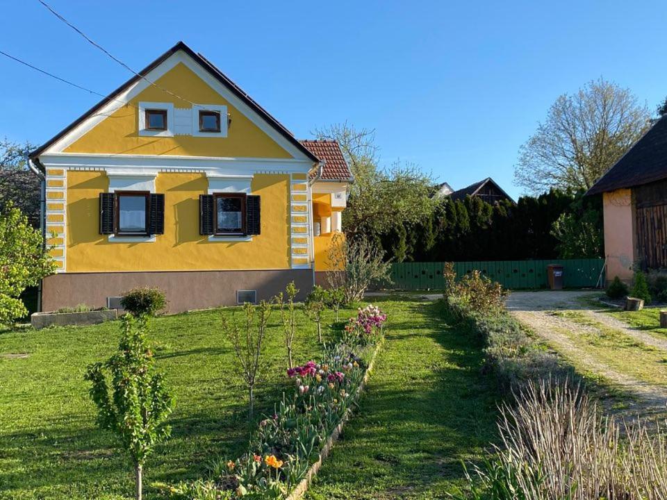una casa gialla con giardino in cortile di Tulipán Vendégház Kercaszomor a Kercaszomor