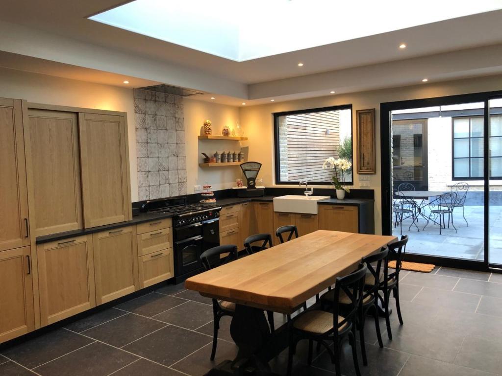 eine Küche mit einem Holztisch und einem Esszimmer in der Unterkunft Les chambres Berguoises Chambre au coeur de Bergues in Bergues