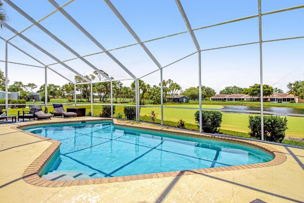 an indoor swimming pool with a pergola next to a golf course at Paradiso Probay in Bradenton