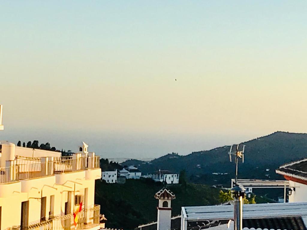 a view of a building with mountains in the background at Casa Competa Centro in Cómpeta