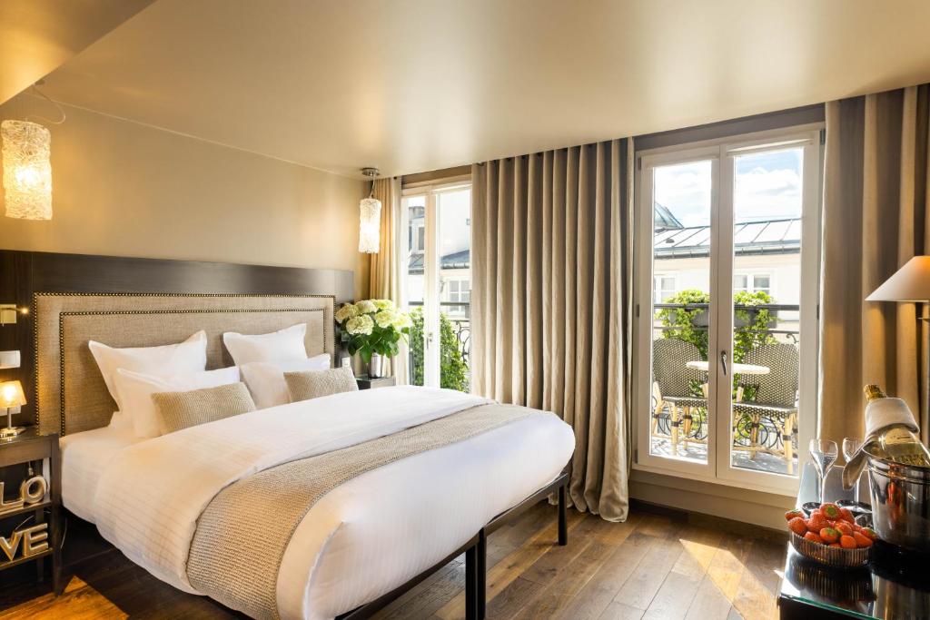 a bedroom with a large bed and a balcony at B Montmartre in Paris