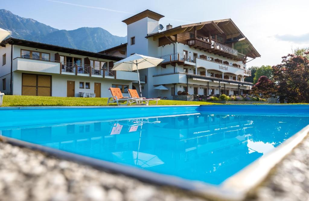 a swimming pool with a pool table and chairs at Hotel Huberhof in Innsbruck