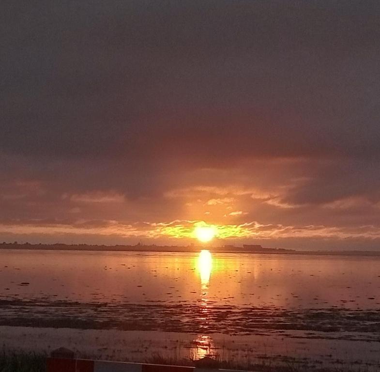 WesterlandにあるKleine Ruheinselの水面に沈む夕日