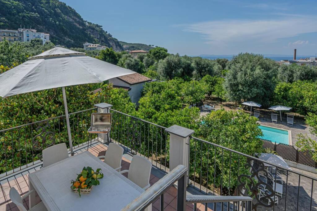 a balcony with a table and an umbrella and a pool at Casa Gege', for up to 5 guests, shared pool, Sorrento center in Sorrento