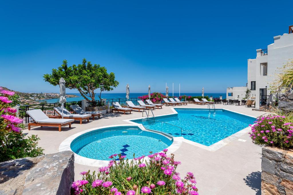 a swimming pool with a view of the ocean at Minois Boutique Hotel in Stalida