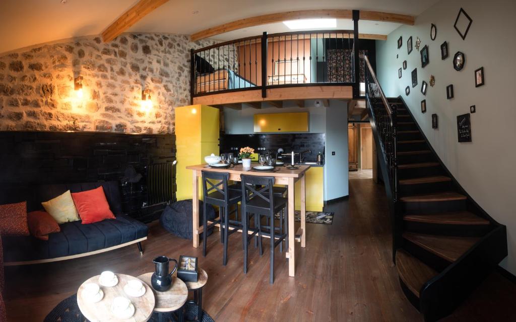 salon ze schodami, kuchnią i stołem w obiekcie Armoise w mieście Saint-Bonnet-le-Froid