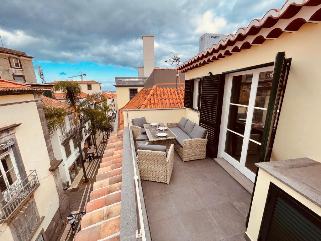 een balkon met een tafel en stoelen in een gebouw bij Living Funchal Apartments in Funchal