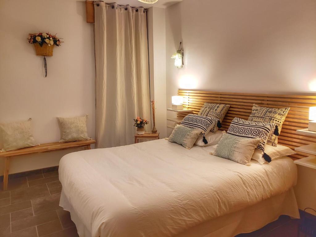 ein Schlafzimmer mit einem großen weißen Bett mit Kissen in der Unterkunft Santiago Sur, Camino Portugués in O Milladoiro