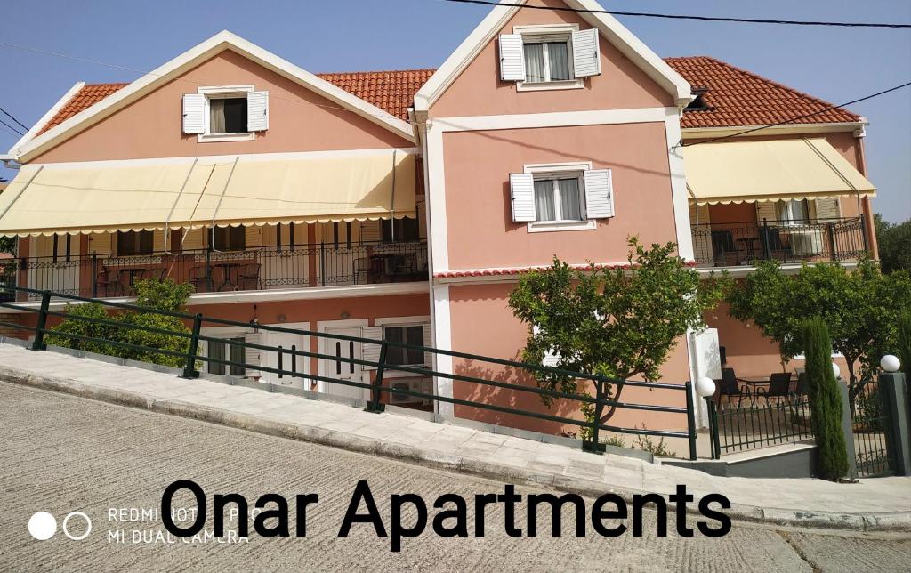 una casa rosa en una calle con las palabras "apartamentos urbanos" en Apartments Onar, en Argostoli