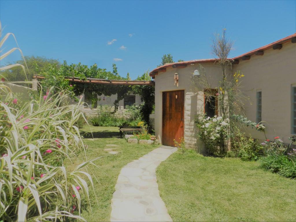 a garden with a house and a path next to a building at Cabaña Kenty Wasy in Humahuaca