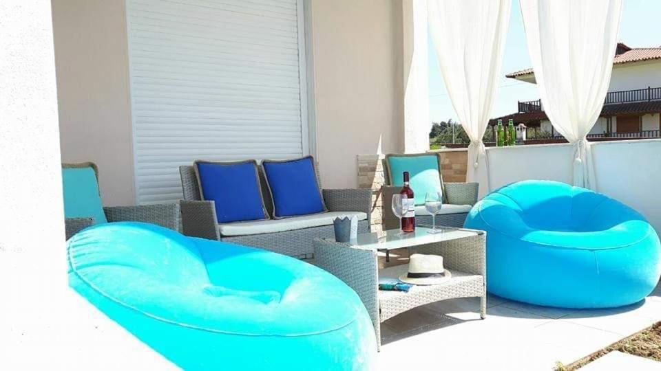 un patio con 2 sillas azules y una mesa en Villa Fokea en Nea Fokea