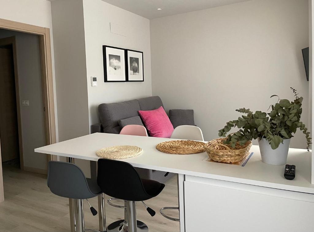 una cucina bianca con tavolo e sedie di Apartamento Puertas del Orbigo 1 a Carrizo de la Ribera
