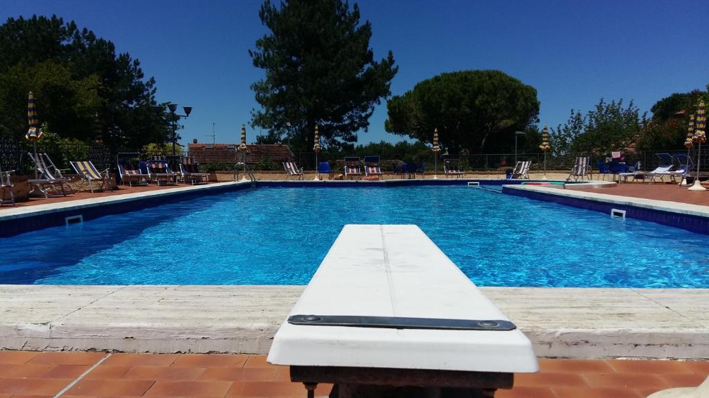 een zwembad met een witte bank ervoor bij Residence Vigna del Mare in Gabicce Mare