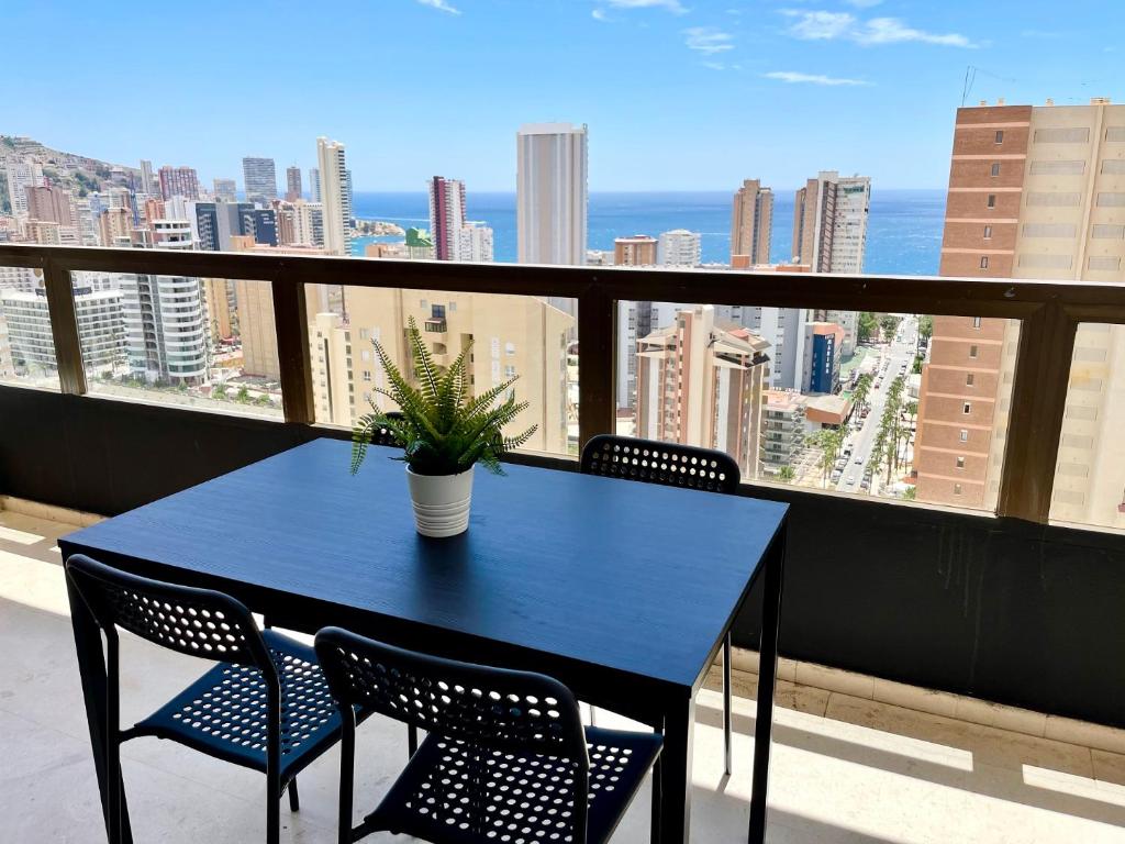 a blue table with chairs and a potted plant on a balcony at Apartamentos Gemelos 2 y 4 by Gestaltur in Benidorm