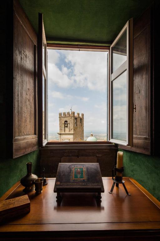 a room with a window with a view of a castle at Appartamento del Capitano in Cortona