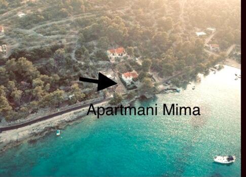 an aerial view of an island in the water with a black arrow at Apartmani Mima in Nečujam