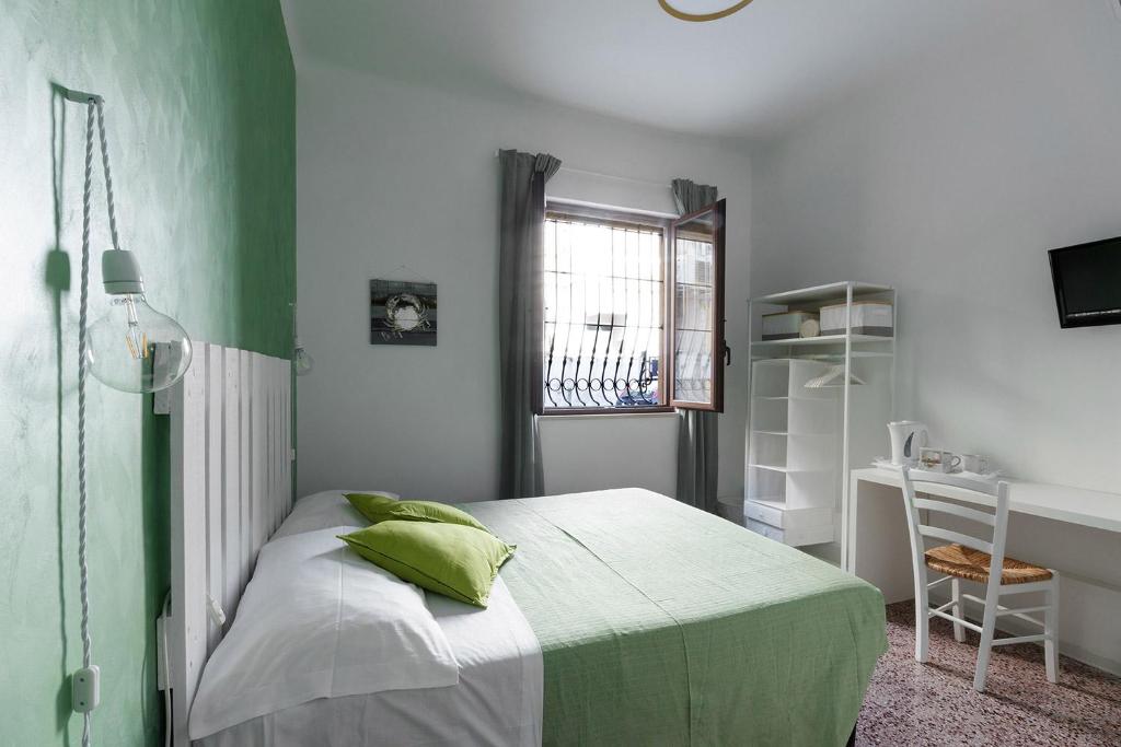 Habitación verde y blanca con cama y escritorio. en Al Borgo Marinaro Guest House, en Civitanova Marche