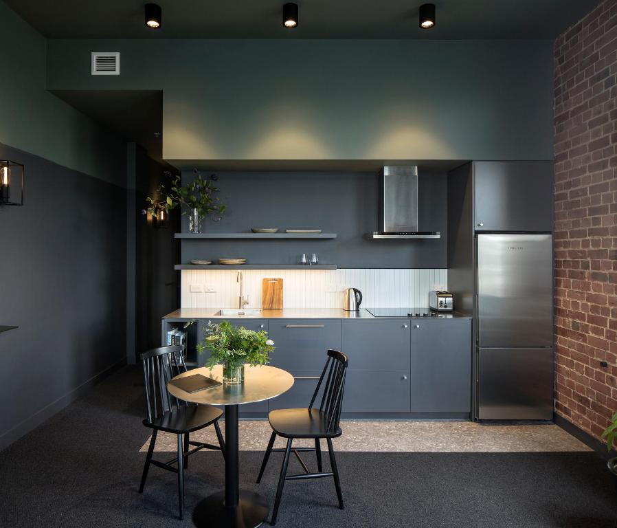 a kitchen with a table and chairs and a refrigerator at The Chamberson in Dunedin