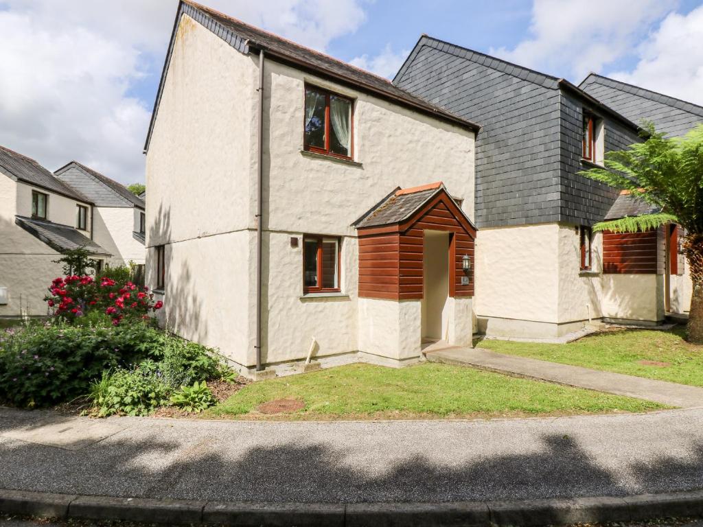 una casa blanca con techo negro en Robinswood, en Falmouth