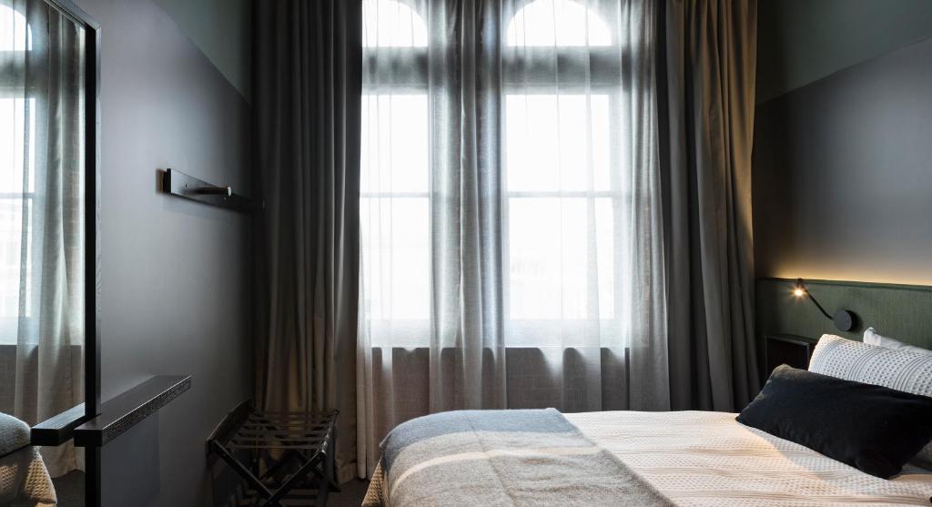 a bedroom with a bed and a large window at The Chamberson in Dunedin