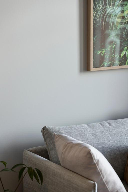 a couch in a living room with a picture on the wall at The Chamberson in Dunedin