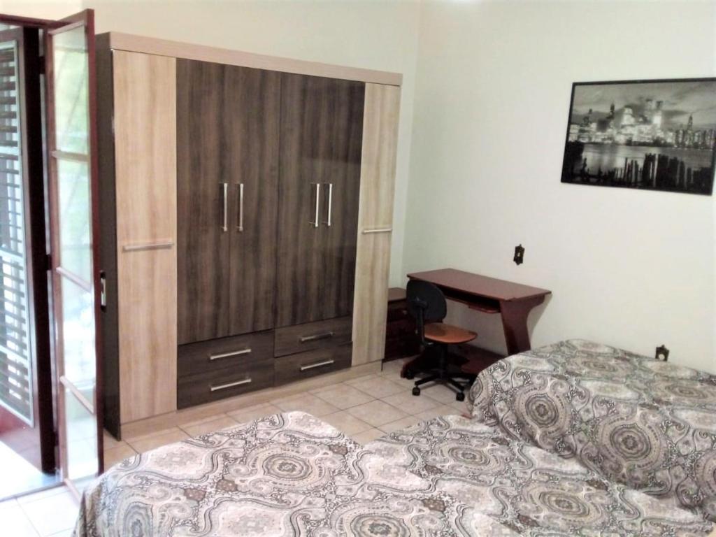 a bedroom with two beds and a desk and a table at Jardim de Londres - Sobrado em Campinas in Campinas