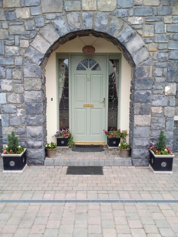 uma porta num edifício de pedra com vasos de plantas em Lír B&B em Multyfarnham