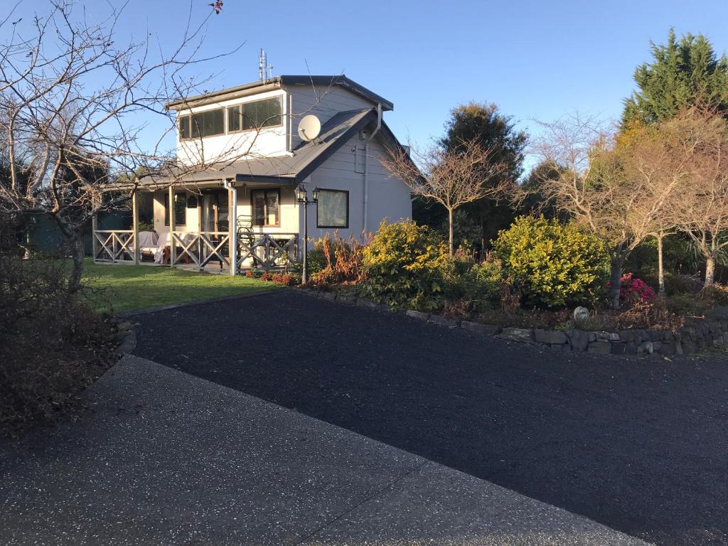 a house with a driveway in front of it at Pet Friendly Country Cottage in Dunedin