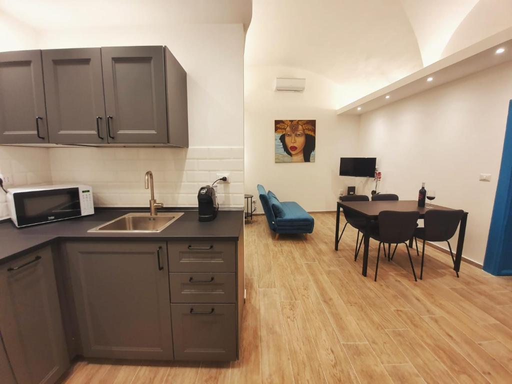kuchnia i jadalnia ze stołem i krzesłami w obiekcie BluMaison - charming holiday home w Katanii