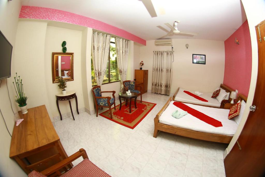 a large room with a bed and a table and chairs at Hotel Farmis Garden in Sylhet