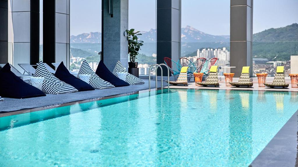 a large swimming pool on a building with chairs at L7 Hongdae in Seoul