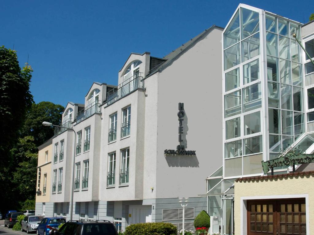 ein großes weißes Gebäude mit vielen Fenstern in der Unterkunft Hotel Am Schlosspark , Wiesbaden in Wiesbaden