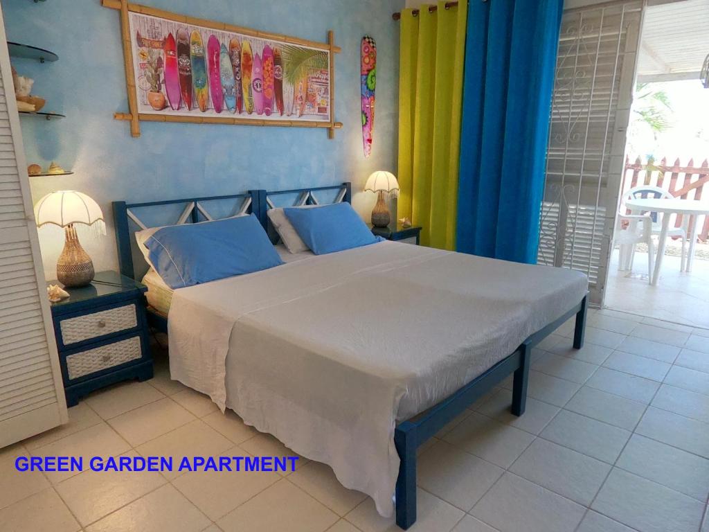 um quarto com uma cama com cortinas azuis e amarelas em Green Garden Apartment em Christ Church